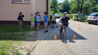 Egzamin praktyczny na kartę rowerową. Uczniowie pokonują rowerem plac manewrowy.