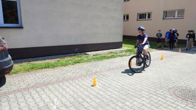 Egzamin praktyczny na kartę rowerową. Uczniowie pokonują rowerem plac manewrowy.