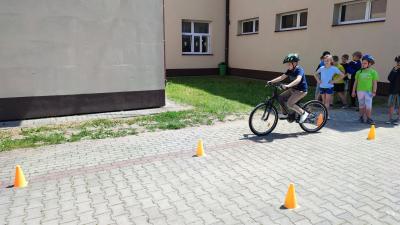 Egzamin praktyczny na kartę rowerową. Uczniowie pokonują rowerem plac manewrowy.