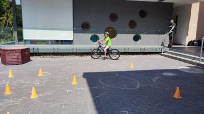 Egzamin praktyczny na kartę rowerową. Uczniowie pokonują rowerem plac manewrowy.