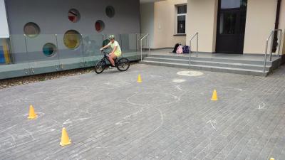 Egzamin praktyczny na kartę rowerową. Uczniowie pokonują rowerem plac manewrowy.
