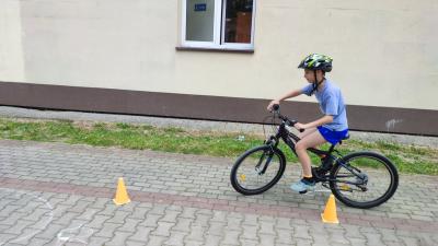 Egzamin praktyczny na kartę rowerową. Uczniowie pokonują rowerem plac manewrowy.