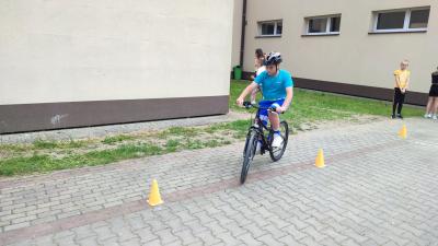 Egzamin praktyczny na kartę rowerową. Uczniowie pokonują rowerem plac manewrowy.