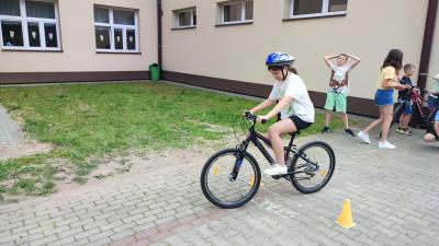 Egzamin praktyczny na kartę rowerową. Uczniowie pokonują rowerem plac manewrowy.