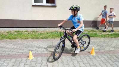 Egzamin praktyczny na kartę rowerową. Uczniowie pokonują rowerem plac manewrowy.