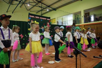 Dzieci z grupy Leśne Duszki stoją na scenie w kolorowych strojach, mówią wierszyk.
