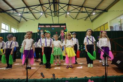 Dzieci z grupy Leśne Duszki tańczą na scenie w kolorowych strojach.
