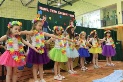 Dziewczynki z grupy Biedronki  tańczą na scenie w kolorowych strojach