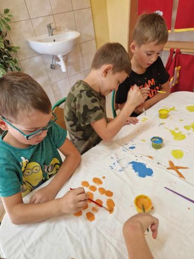 dzieci malują farbą na tkaninie
