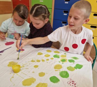 dzieci malują farbami kropki na materiale