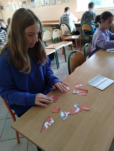 Dziewczynka z klasy 6 układa puzzle – herb Litwy