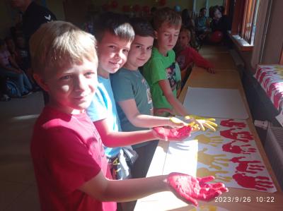 Czwórka chłopców odciska swoje dłonie w barwach flagi Hiszpanii.
