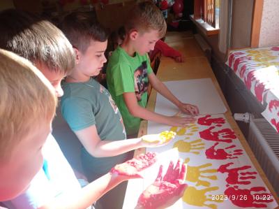 Czwórka chłopców odciska swoje dłonie w barwach flagi Hiszpanii.