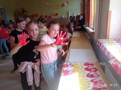 Dwie dziewczynki odciskają swoje dłonie w barwach flagi Hiszpanii.