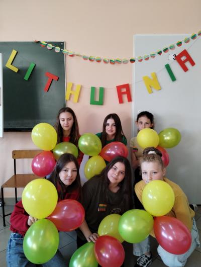 Sześć dziewcząt z balonami na tle napisu Lithuania