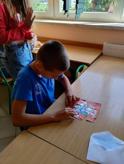 Uczeń z klasy 6 z ułożonym z puzzli herbem Litwy
