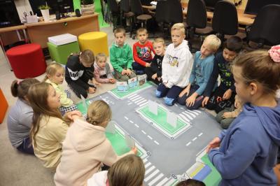 Uczniowie klasy 3a siedzą wokół maty przedstawiającej plan miasta.