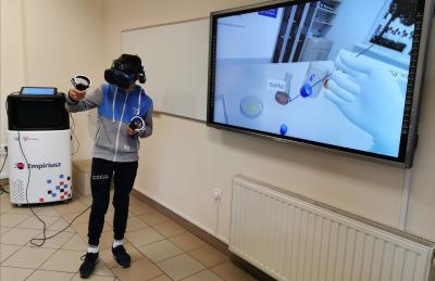 Chłopiec  w goglach VR wykonuje doświadczenie  „Otrzymywanie kwasu siarkowego IV”