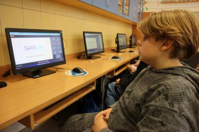 Uczniowie klasy VIIb uczestniczą w webinarze poświęconym programowi Tinkercad. Wszyscy siedzą przed komputerami.