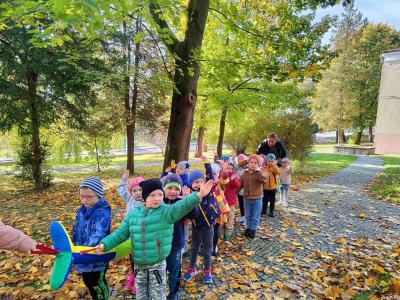 Grupa Sówki. dzieci idą przez park trzymając węża spacerowego i machają. wokół pełno liści jesiennych.