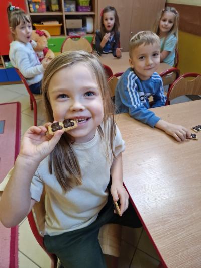 Dzieci jedzą ciasteczka w kształcie misia