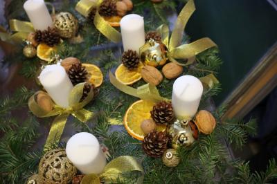 Stroiki bożonarodzeniowe wykonane z pieńka drewnianego, świecy, gałązek jodłowych, szyszek, orzechów i bombek.