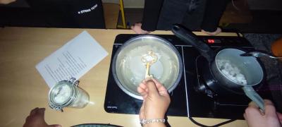 Garnek z woda i podgrzanym woskiem, przygotowanie do lania wosku