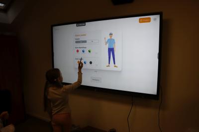 Uczniowie wykorzystują uczenie maszynowe na tablicy interaktywnej w celu zaprogramowania zachowania robota.
