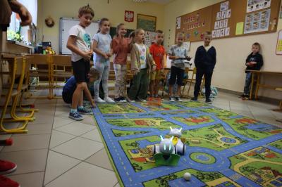 Uczniowie rozgrywają mecz piłki nożnej wykorzystując robota Photona.