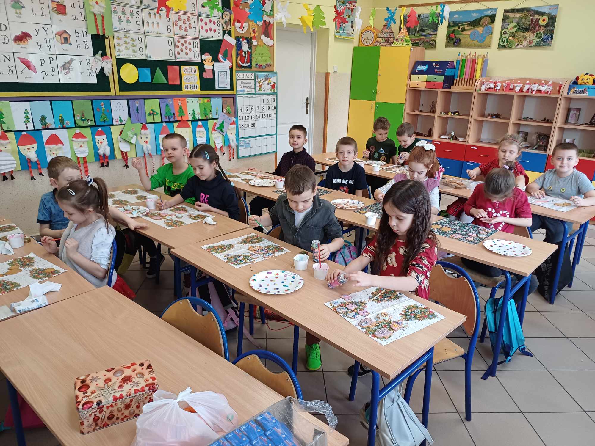 Uczniowie klasy pierwszej dekorują pierniczki podczas warsztatów.