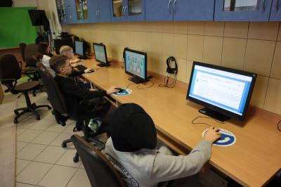 Uczniowie siedzący przy komputerach - grają w grę związaną z cyberbezpieczeństwa.