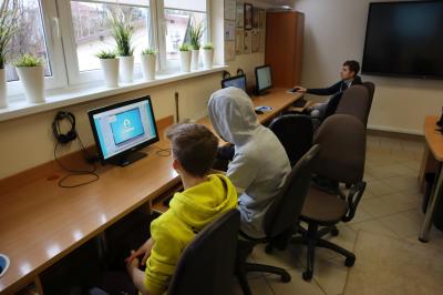 Uczniowie siedzący przy komputerach - grają w grę związaną z cyberbezpieczeństwa.