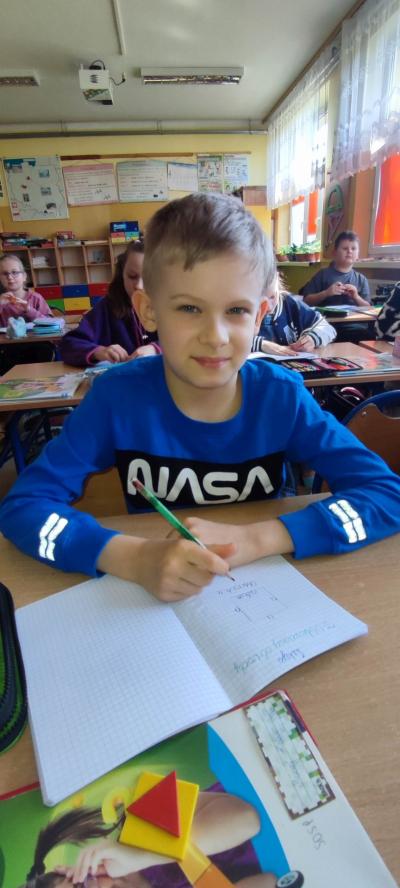 Uczeń robi notatki na lekcji matematyki