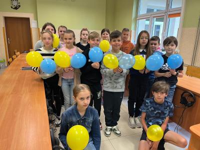 uczniowie klasy 4 stoją w klasie z balonami