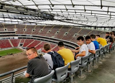 młodzież siedzi na trybunach stadionu.