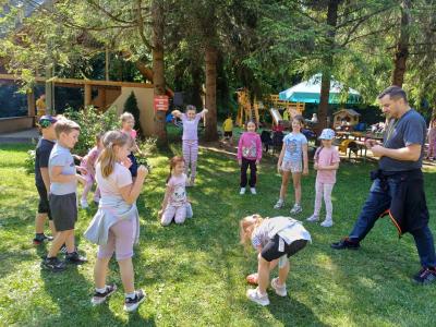 Grupka dzieci bawi się w zabawę ruchową na trawie