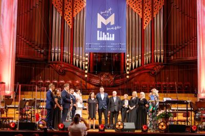 Grupa osób stojąca na scenie Filharmonii Narodowej