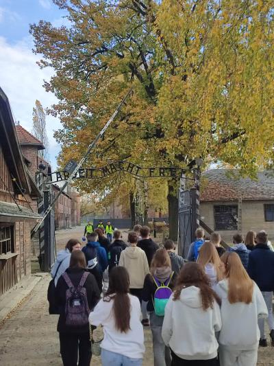 Uczniowie klas 8 przechodzą przez bramę główną w obozie