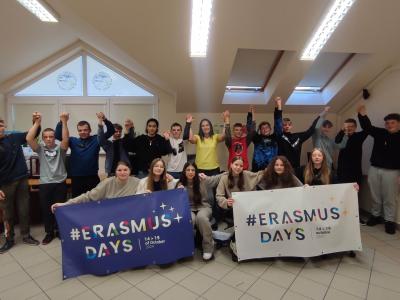 Uczniowie z napisem Erasmus + i banerami promocyjnymi.