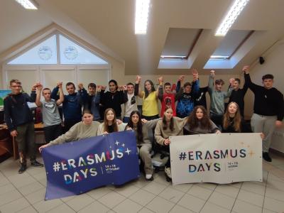 Uczniowie z napisem Erasmus + i banerami promocyjnymi.