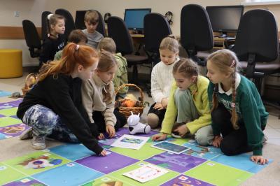 Uczniowie programują robota Photon aby pokonał jesienną trasę na macie edukacyjnej.