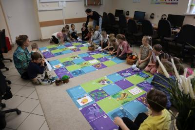 Uczniowie programują robota Photon aby pokonał jesienną trasę na macie edukacyjnej.