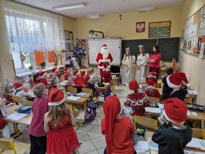 W klasie dzieci stojące twarzami do Mikołaja i aniołków w rozsypce w klasie szkolnej,