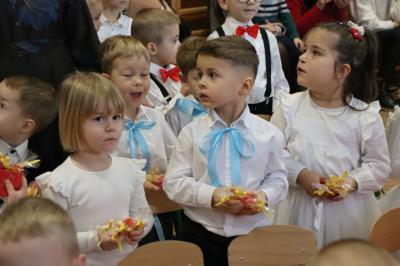 Grupka dzieci w białych bluzeczkach pozuje do zdjecia