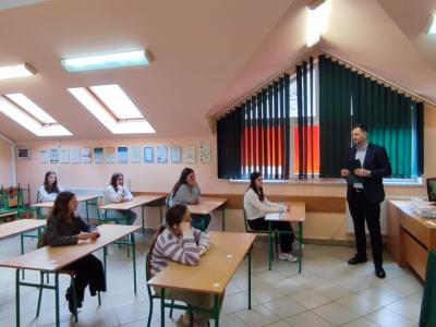 nauczyciel wraz z grupą uczniów siedzących w ławkach