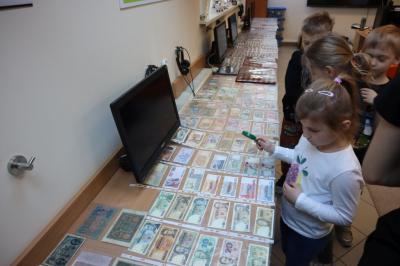 Uczniowie uczestniczą w prelekcji i oglądają kolekcję monet.