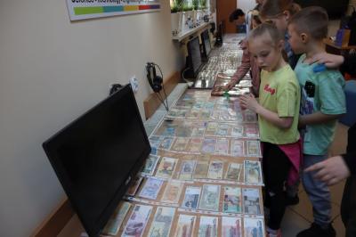 Uczniowie uczestniczą w prelekcji i oglądają kolekcję monet.