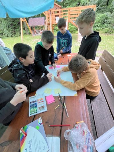 dzieci z klasy 4 rysują plakat związany z przyjaźnią