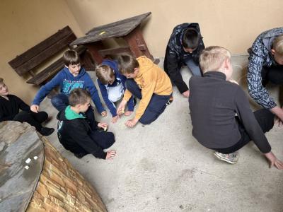 dzieci z klasy 4 rysują symbol przyjażni kredą na betonie
