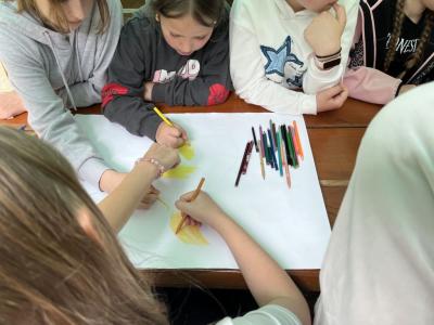 dzieci z klasy 4a rysują plakat związany z przyjaźnią